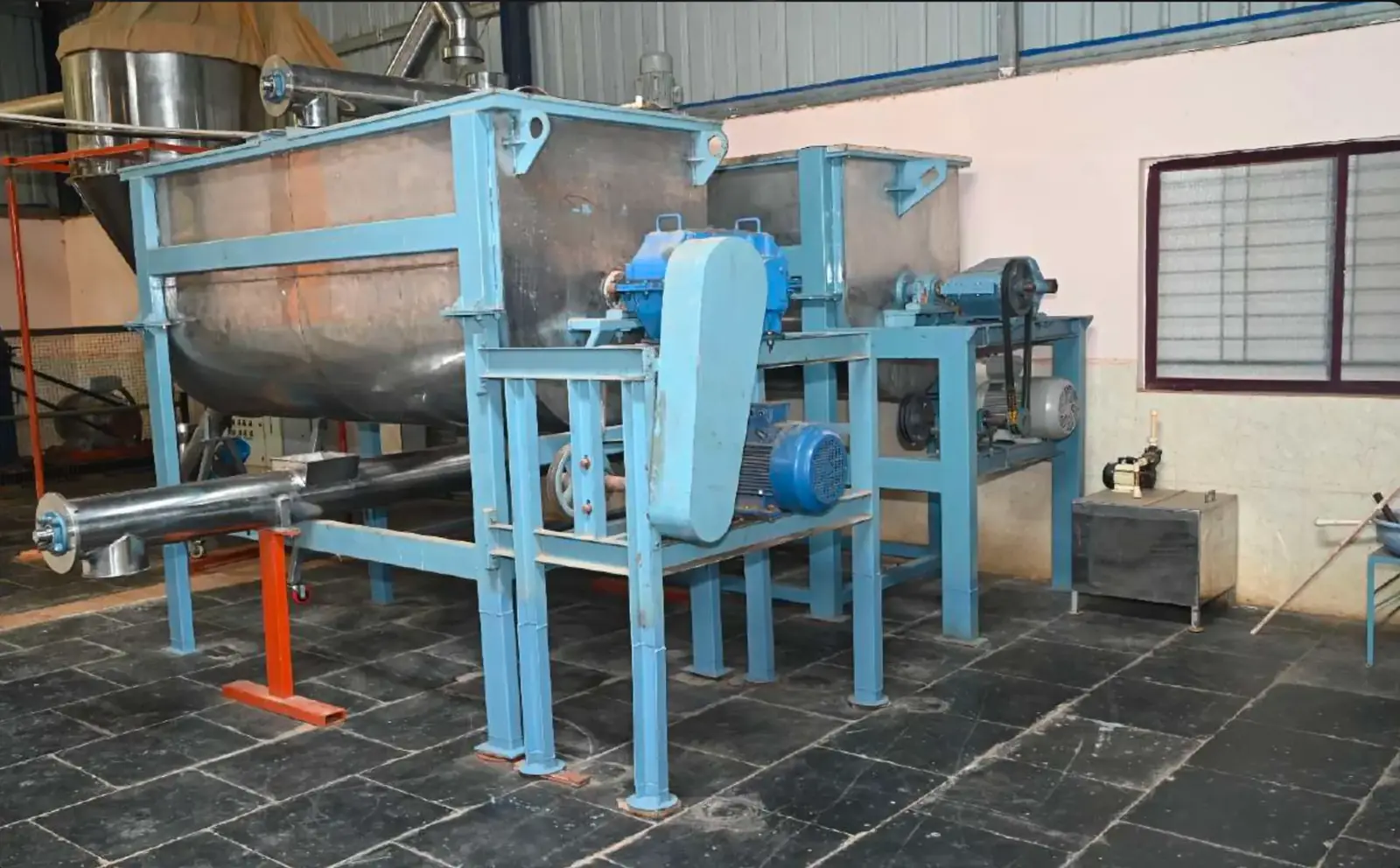 Twin industrial ribbon blenders and screw conveyor inside the MKB Enterprises spice blending hall